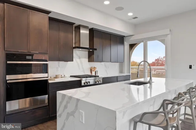 a kitchen with stainless steel appliances granite countertop a stove top oven a sink and white cabinets