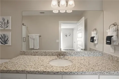 a bathroom with a granite countertop sink a toilet and shower