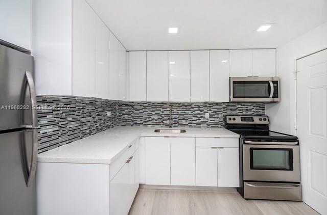 9760 Southwest 184th Street, Unit 6D Cutler Bay, FL 33157 - Photo 6 of 16 a kitchen with a sink and a stove top oven