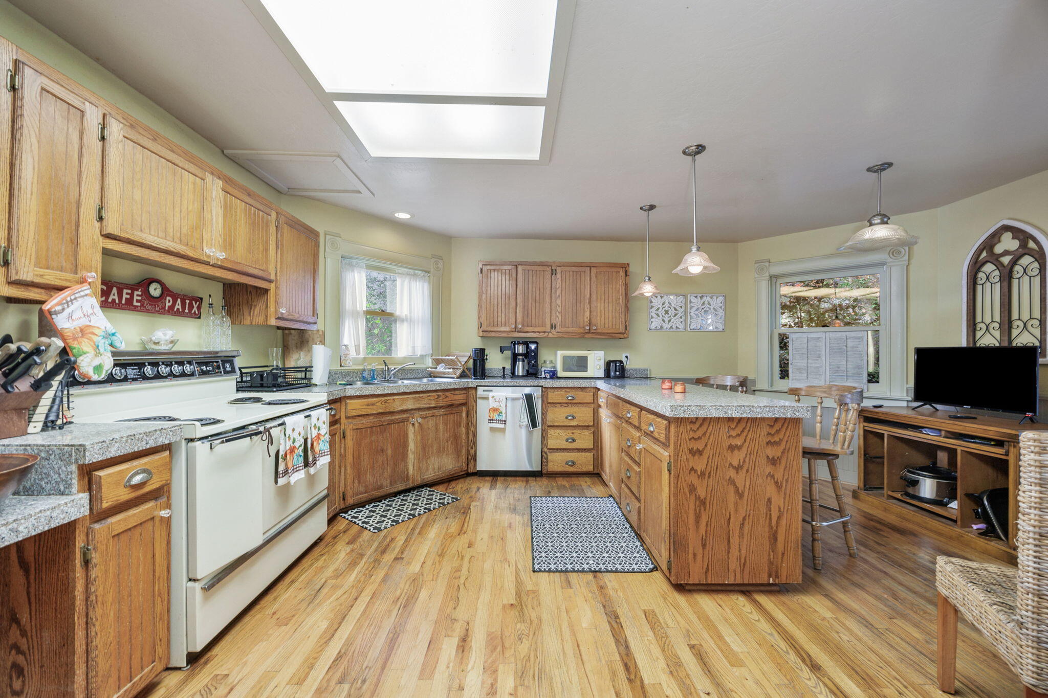 75 Wimer Street Ashland, OR 97520 - Photo 15 of 44 a large kitchen with stainless steel appliances granite countertop a large stove a sink dishwasher and a microwave oven with wooden floor
