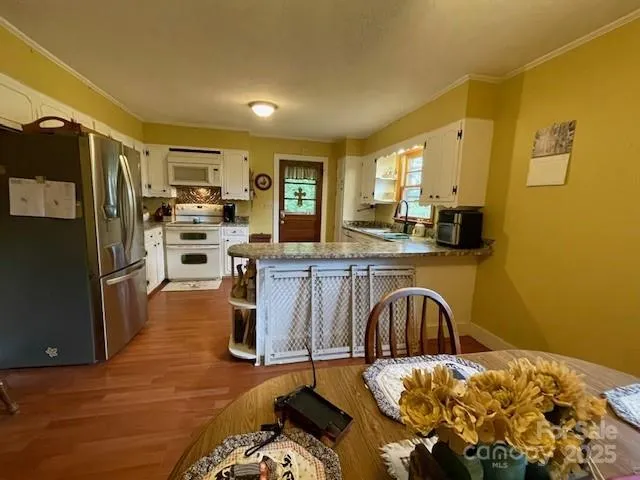 a kitchen with stainless steel appliances kitchen island granite countertop a refrigerator and a stove