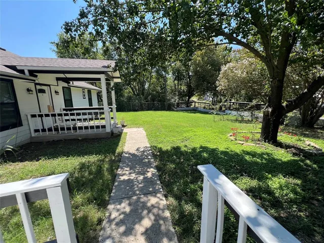 a view of a house with backyard and sitting area