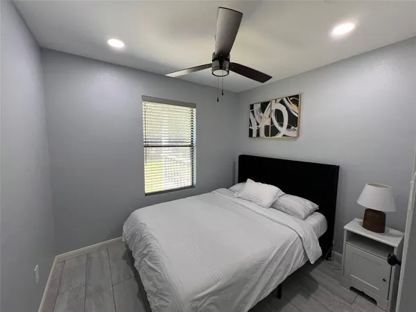 a bedroom with a large bed and a chandelier