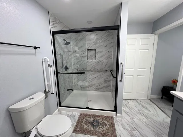 a bathroom with a toilet and a shower