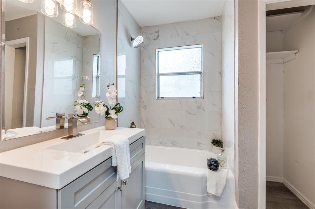 421 West 8th Street Lancaster, TX 75146 - Photo 14 of 28 Bathroom featuring a light gray vanity with an integrated sink, a large mirror, and a contemporary vanity light fixture