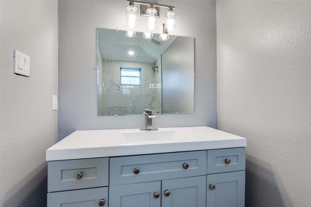 421 West 8th Street Lancaster, TX 75146 - Photo 17 of 28 Bathroom vanity featuring a light gray cabinet with brushed nickel hardware