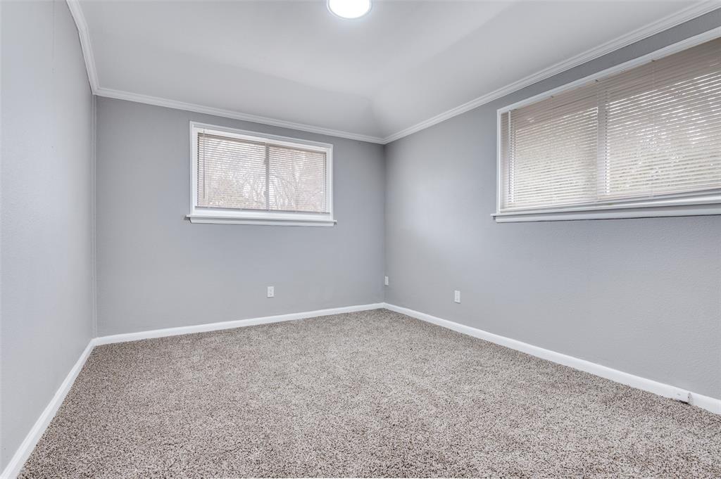421 West 8th Street Lancaster, TX 75146 - Photo 18 of 28 Room featuring light gray walls, white trim, two windows with blinds, and gray carpeting