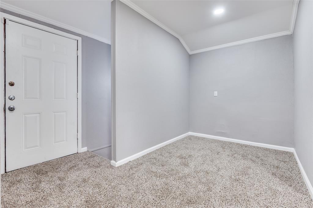 421 West 8th Street Lancaster, TX 75146 - Photo 19 of 28 Entryway featuring a four-panel door with multiple locks, soft gray walls, white baseboards, white crown molding, and light gray carpet flooring