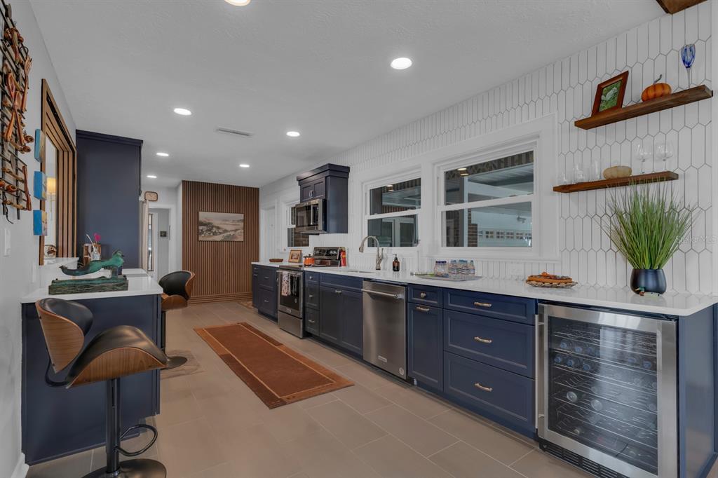 1322 Riverside Drive Titusville, FL 32780 - Photo 6 of 21 a large living room with stainless steel appliances kitchen island granite countertop furniture a rug and a window
