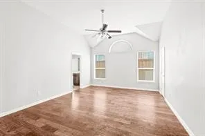 an empty room with windows and ceiling fan