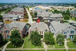 an aerial view of residential houses with outdoor space and parking