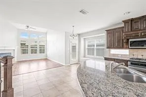a kitchen with stainless steel appliances granite countertop a sink and a stove next to a large window