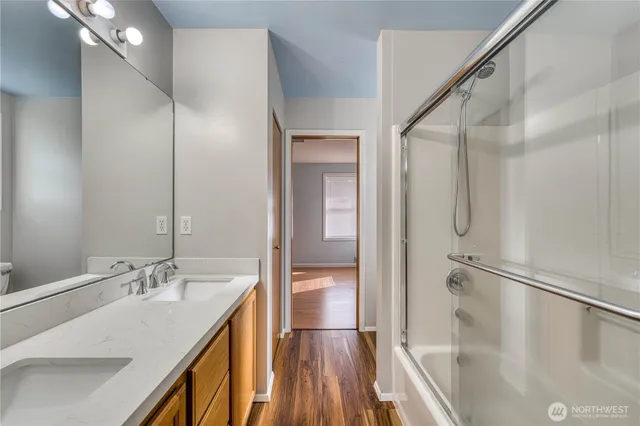 a bathroom with a granite countertop sink a mirror and shower