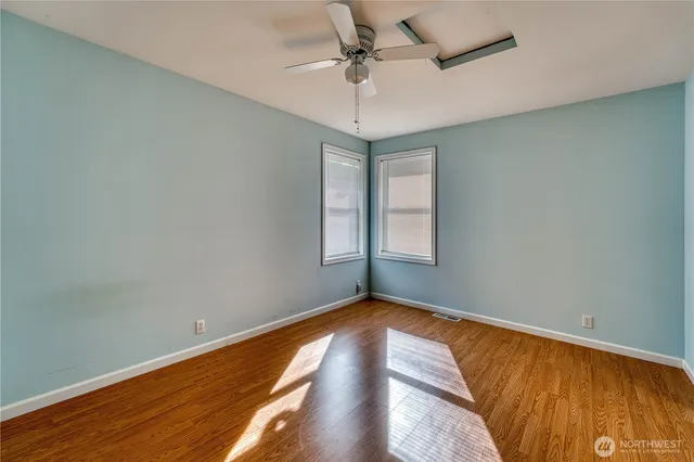 an empty room with a window and wooden floor