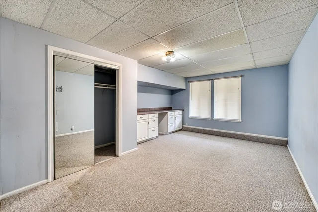 an empty room with windows and cabinet