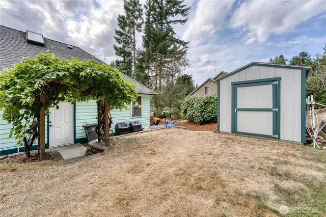 a view of house with backyard and trees