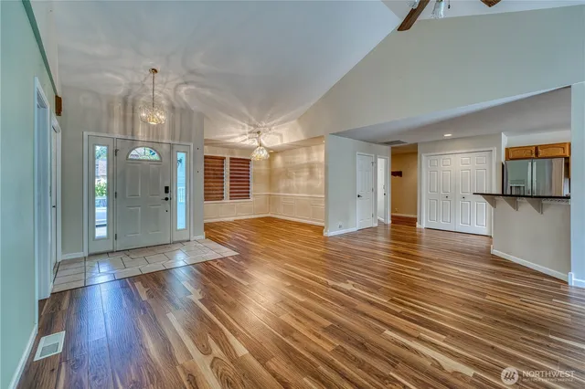 a view of a big room with wooden floor and a kitchen