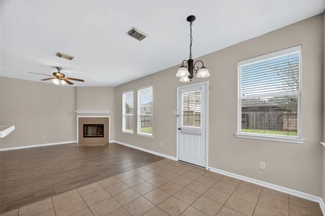 a view of an empty room with a window and fireplace