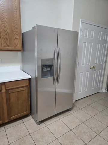 a kitchen with cabinets and a refrigerator