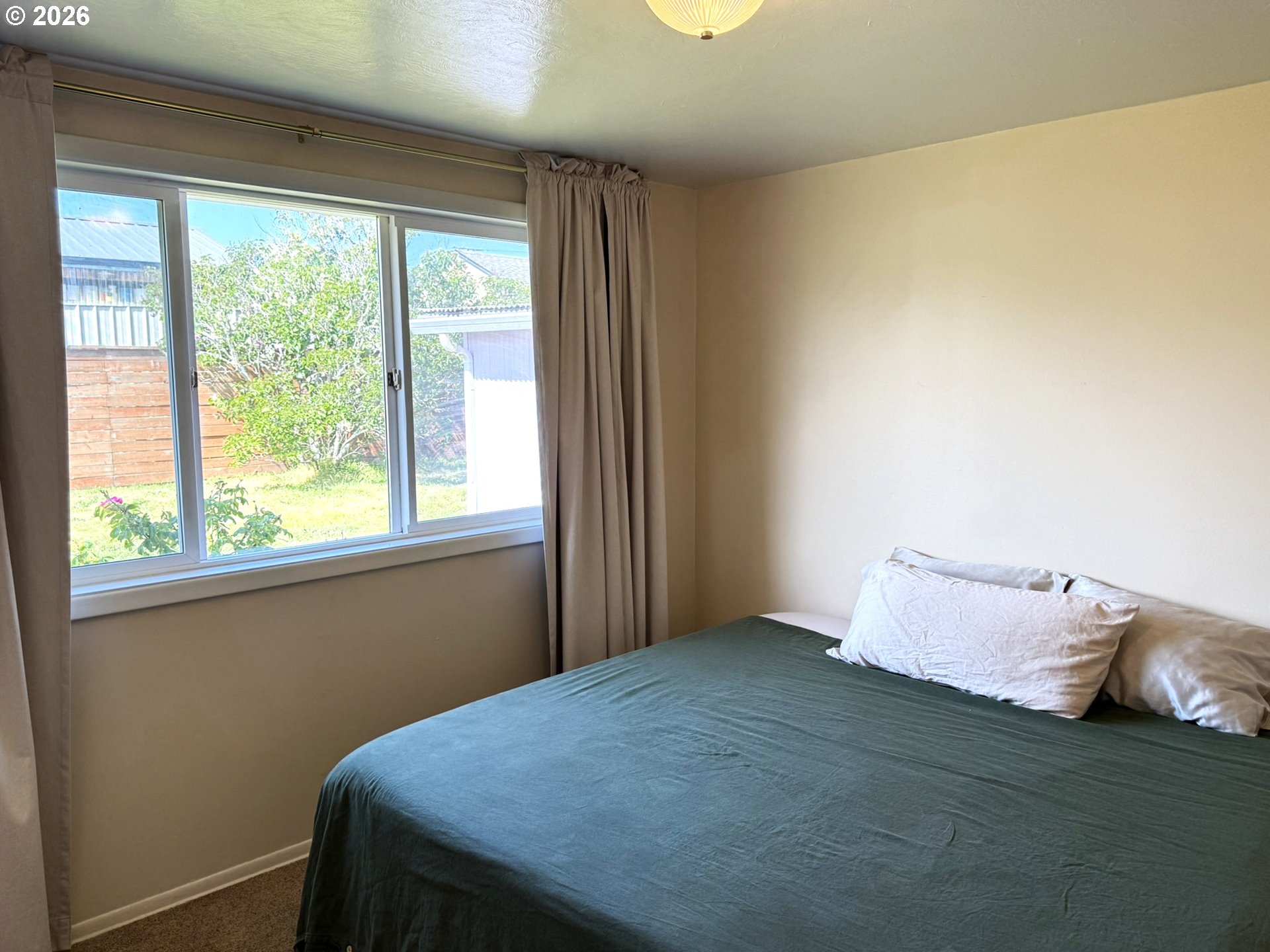 1179 6th Street Florence, OR 97439 - Photo 20 of 26 a bed sitting in a bedroom next to a window
