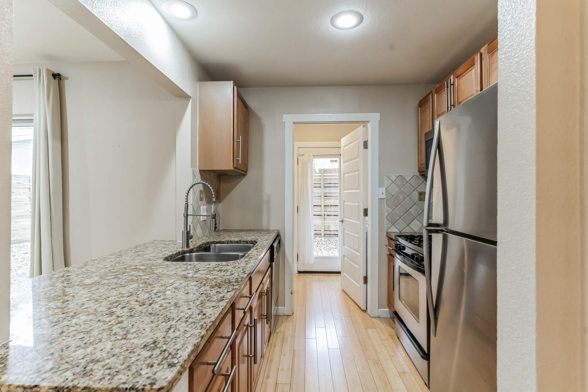 3214 Clawson Road, Unit A Austin, TX 78704 - Photo 7 of 26 Streamlined culinary space with light wood cabinetry and lustrous granite countertops, perfect for daily living.