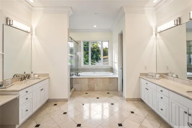 a bathroom with a double vanity sink large mirror and a bathtub