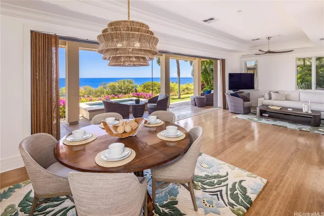 a view of a dining room with furniture a chandelier and wooden floor