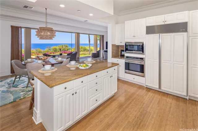 a kitchen with stainless steel appliances kitchen island granite countertop a stove a sink and a refrigerator