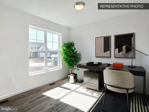 a view of a workspace with furniture and a window