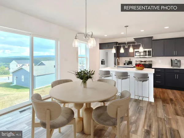 a kitchen with stainless steel appliances kitchen island granite countertop a table and chairs in it