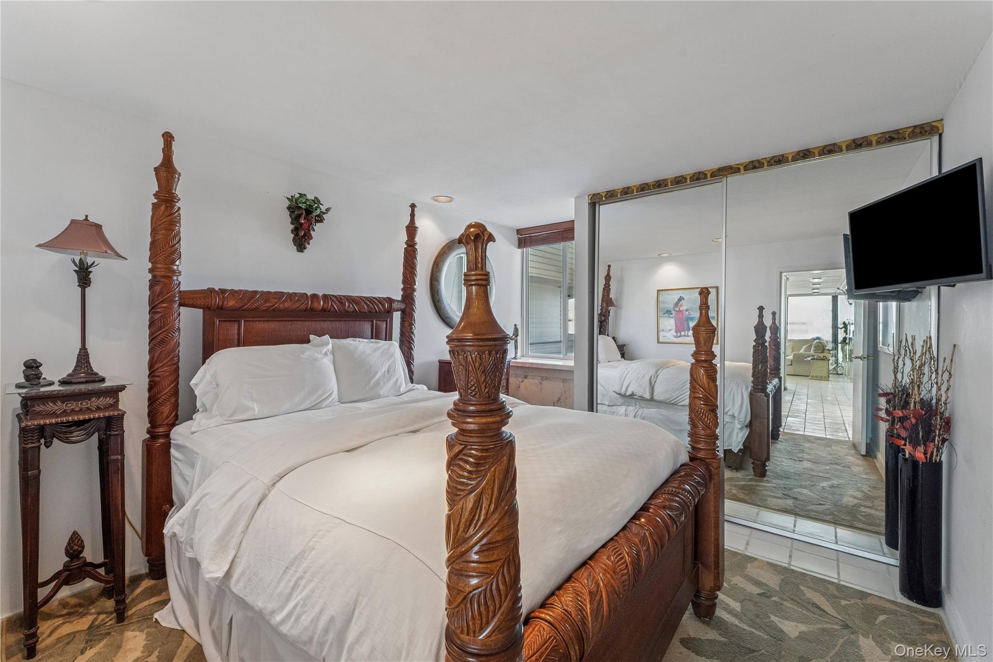 253 Dune Road, Unit 48 Westhampton Beach, NY 11978 - Photo 12 of 28 a bedroom with a bed and a flat screen tv