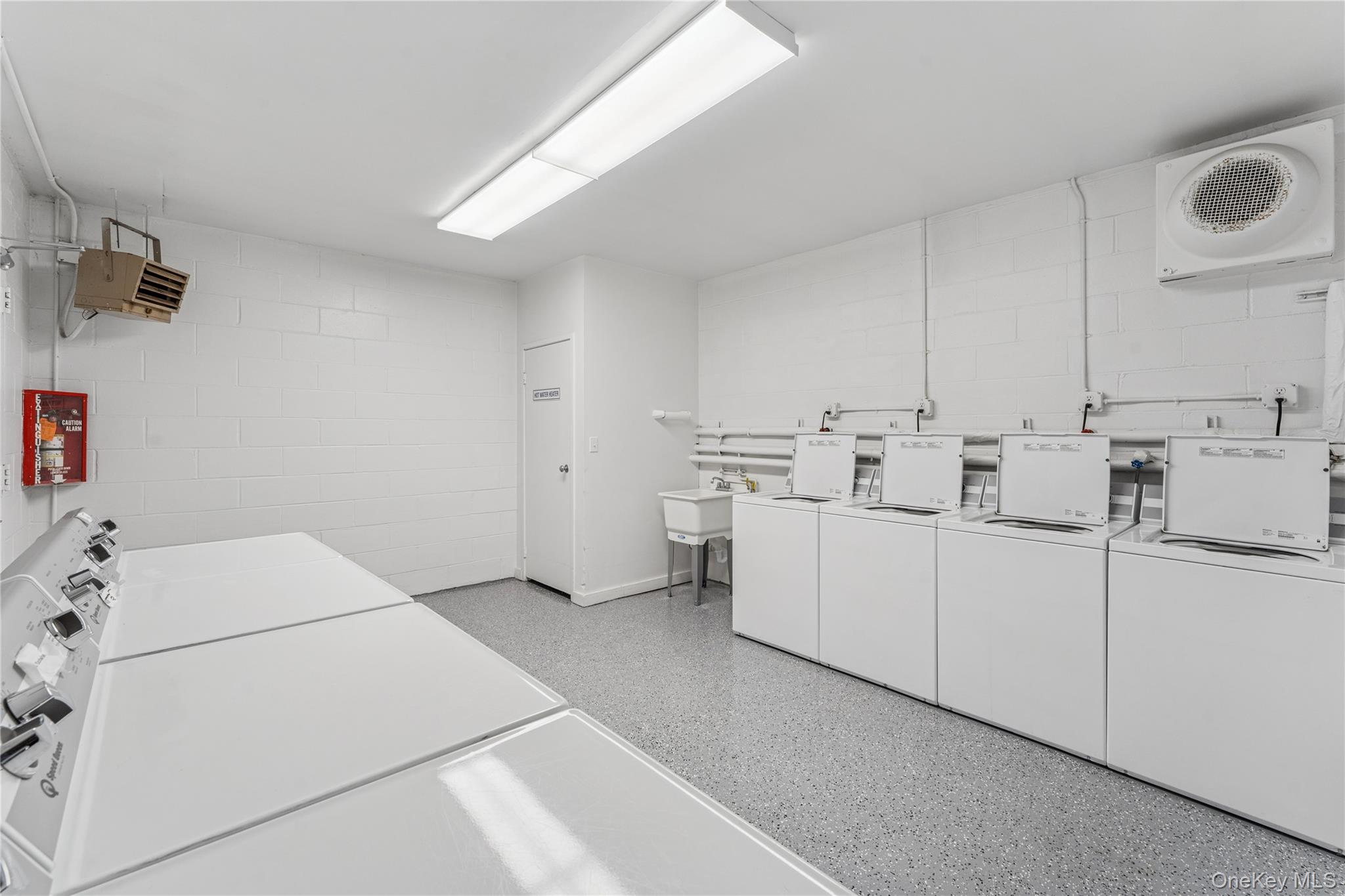 253 Dune Road, Unit 48 Westhampton Beach, NY 11978 - Photo 17 of 28 a utility room with cabinets washer and dryer