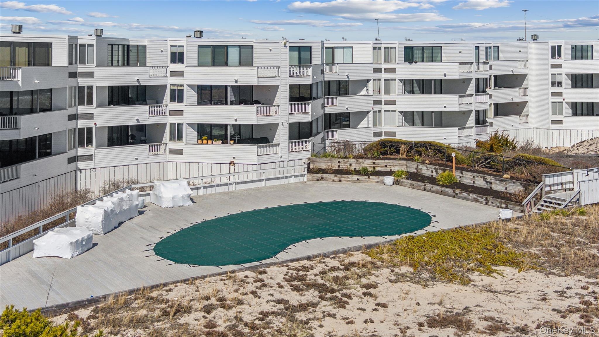 253 Dune Road, Unit 48 Westhampton Beach, NY 11978 - Photo 24 of 28 a view of a building with a garden