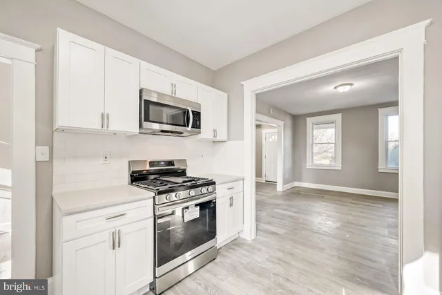 a kitchen with granite countertop a stove top oven microwave and cabinets