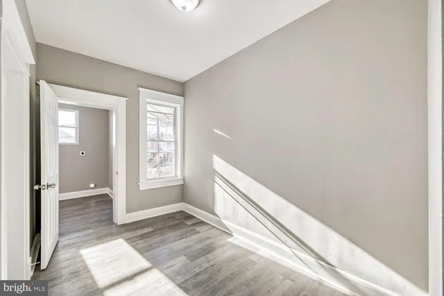 a view of bedroom with window and wooden floor