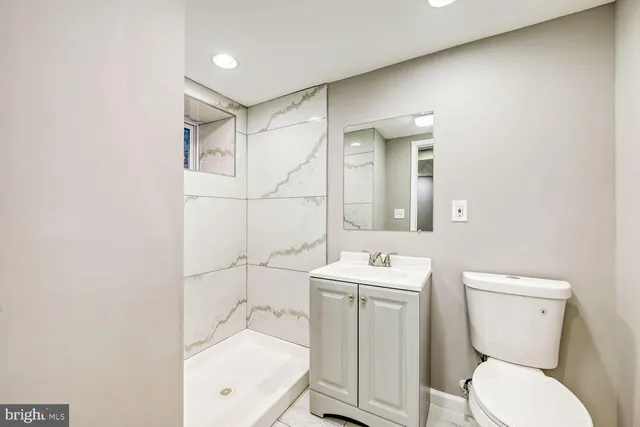 a bathroom with a toilet a sink and mirror