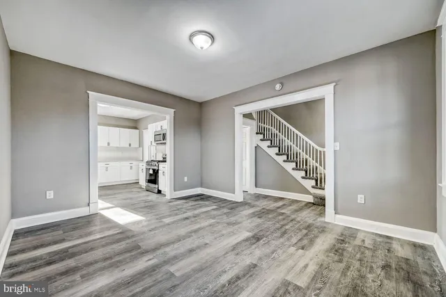 a view of an empty room with wooden floor and entryway