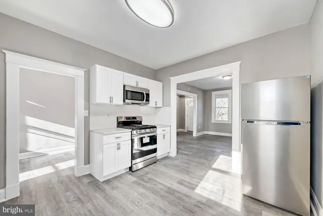 a kitchen with stainless steel appliances a stove a refrigerator and cabinets