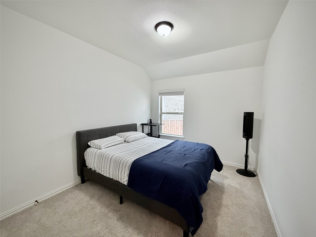 1209 Cole Ests Drive Georgetown, TX 78628 - Photo 11 of 33 Bedroom with carpet, lofted ceiling, and a textured ceiling