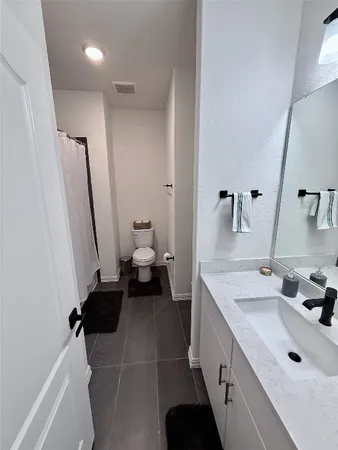 a bathroom with a sink and mirror with toilet