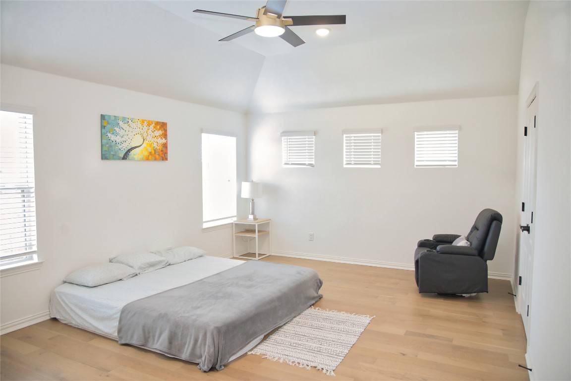 1209 Cole Ests Drive Georgetown, TX 78628 - Photo 26 of 33 Bedroom with light wood-type flooring, multiple windows, lofted ceiling, and a ceiling fan