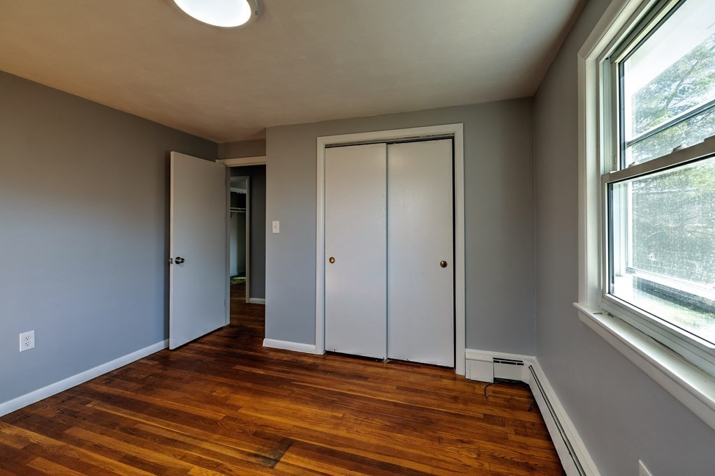 138 Coy Hill Road Warren, MA 01083 - Photo 17 of 42 a view of an empty room with wooden floor and a window