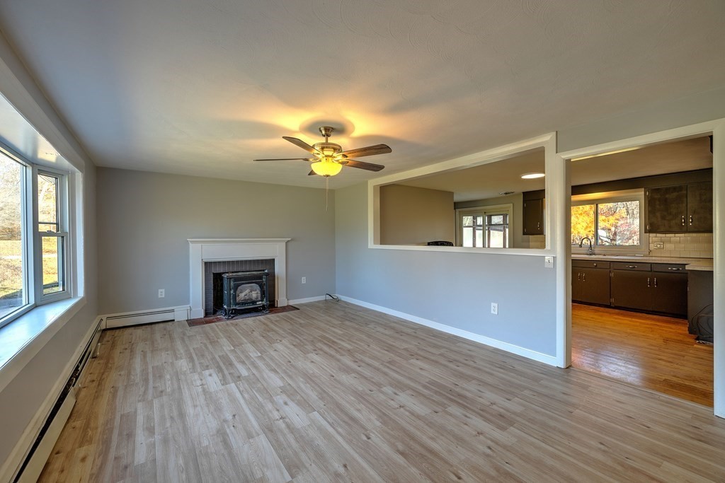138 Coy Hill Road Warren, MA 01083 - Photo 3 of 42 a view of a livingroom with a fireplace wooden floor and a kitchen