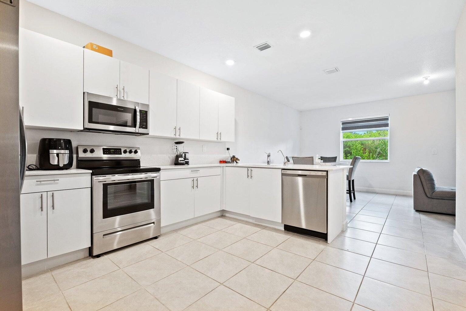 2701 Southeast 10th Street Homestead, FL 33035 - Photo 1 of 23 a kitchen with granite countertop a sink a counter top space appliances and cabinets