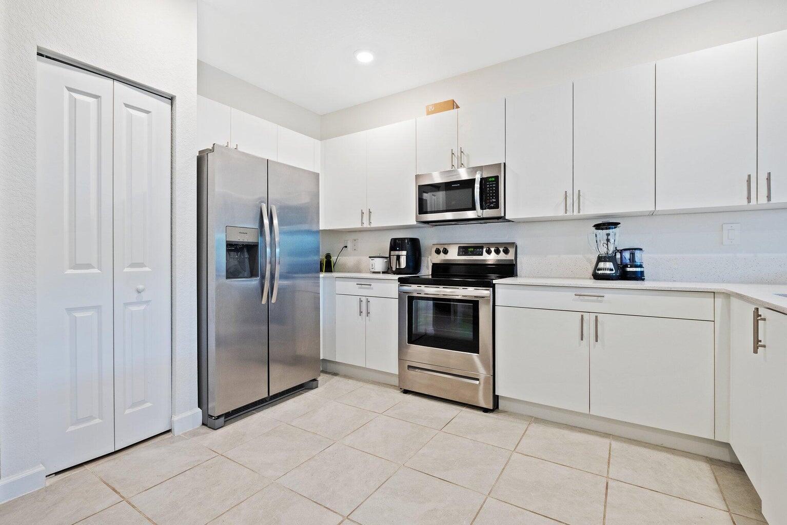 2701 Southeast 10th Street Homestead, FL 33035 - Photo 5 of 23 a kitchen with white cabinets and stainless steel appliances