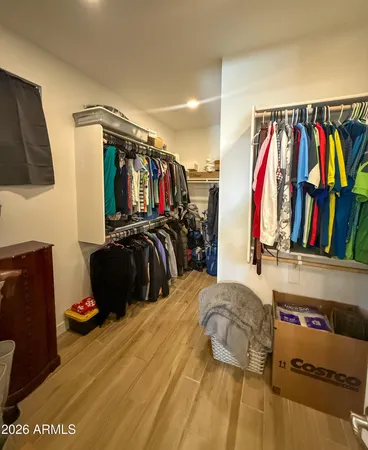a view of walk in closet with clothes and shoes