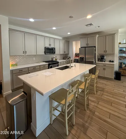 a kitchen with a dining table chairs stove refrigerator and cabinets