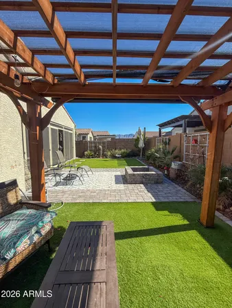 a view of a backyard with table and chairs under an umbrella