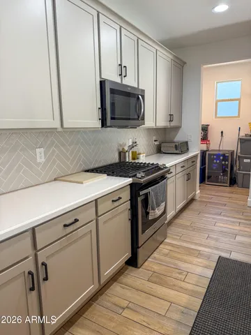 a kitchen with stainless steel appliances granite countertop a stove a sink and a microwave