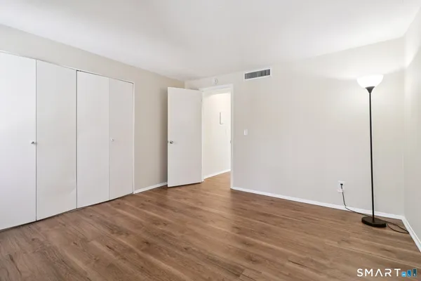a view of an empty room with wooden floor